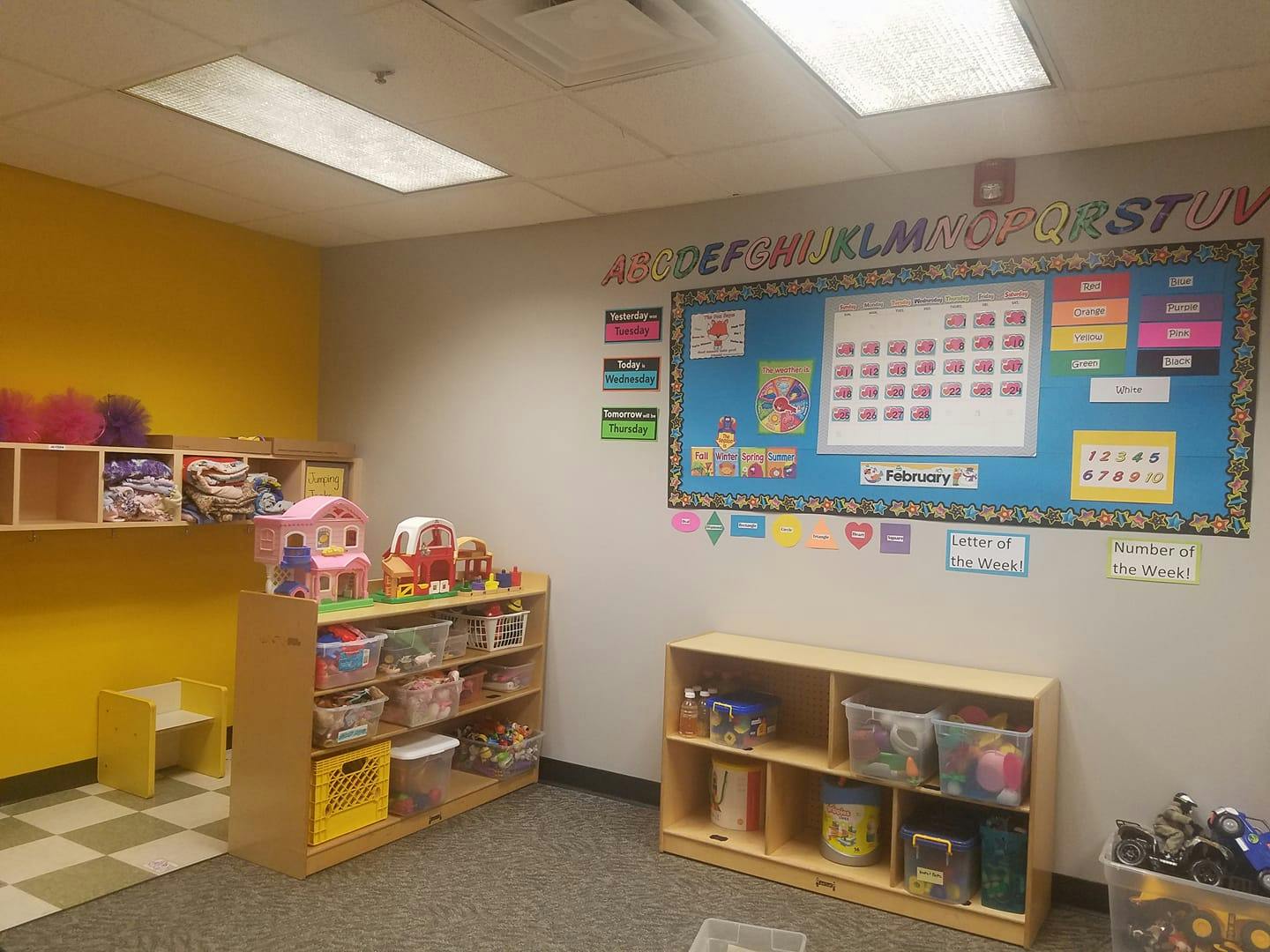 Classroom with shelves of toys and a bulletin board with a calendar