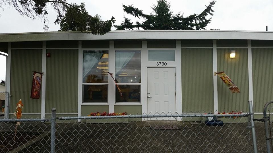 Exterior of a building with a door and windows behind a chain link fence