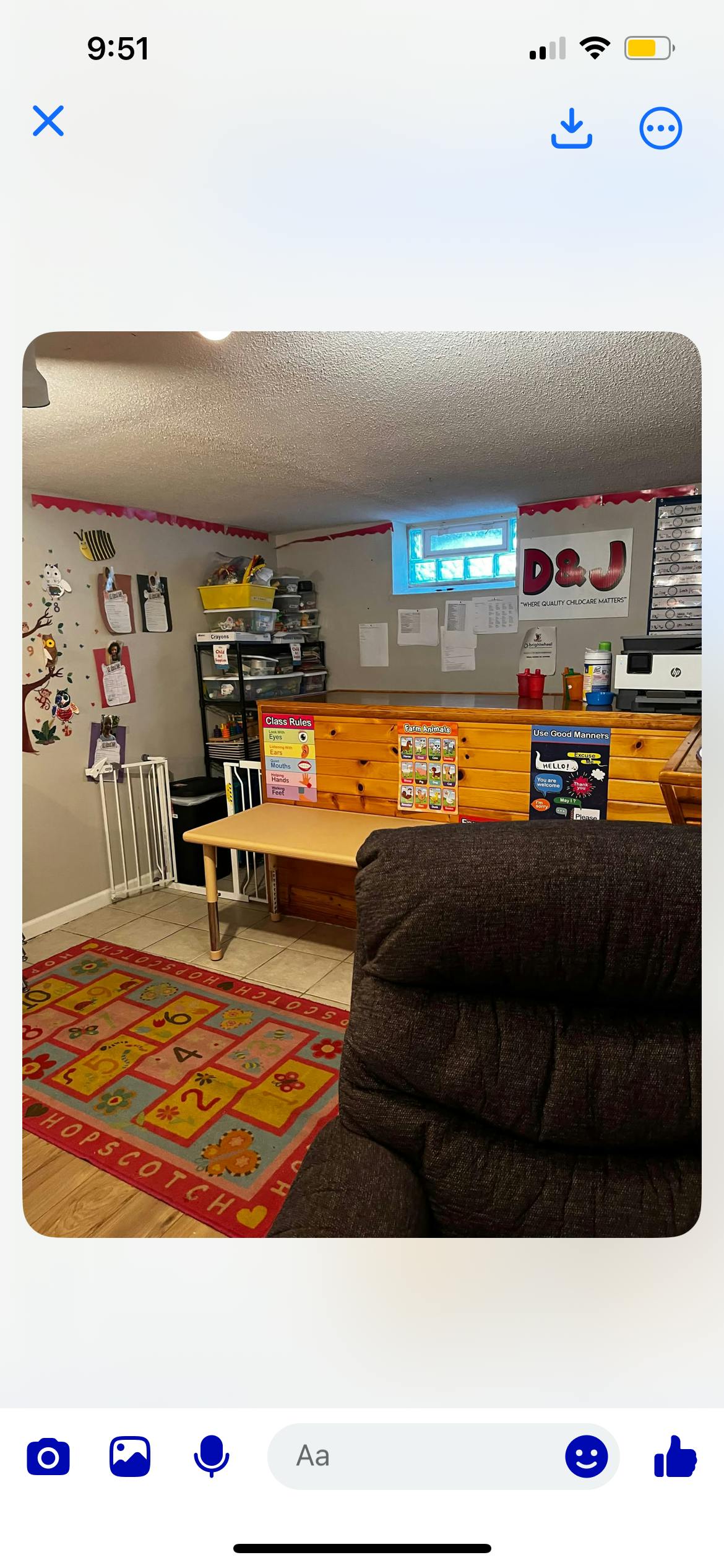 A room with a hopscotch rug, a table, and a dark chair