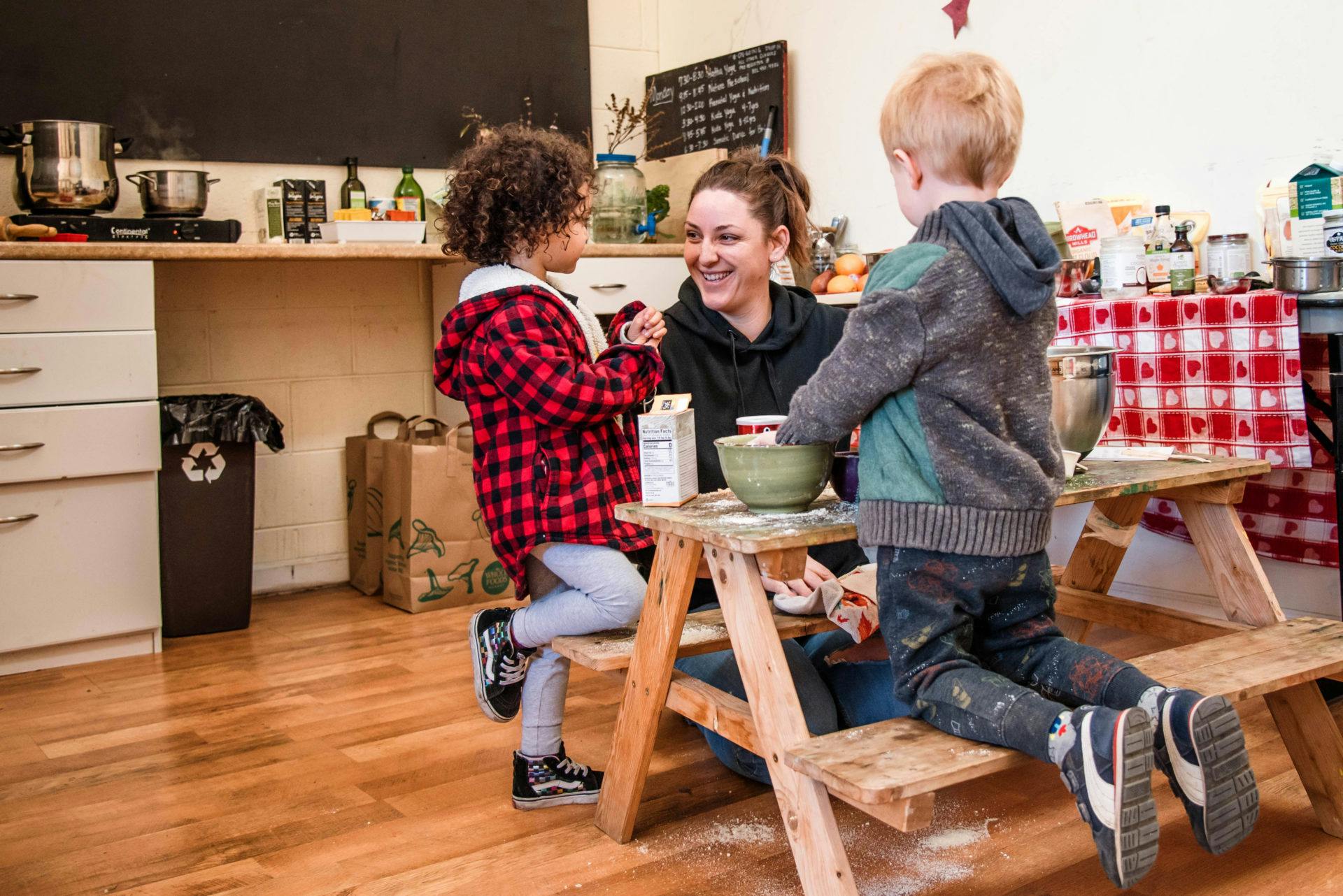 Adult and two children at a small wooden table