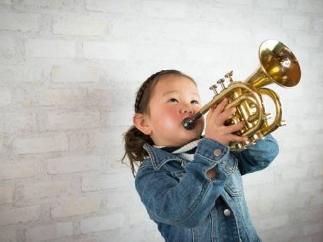 Child playing a small brass instrument
