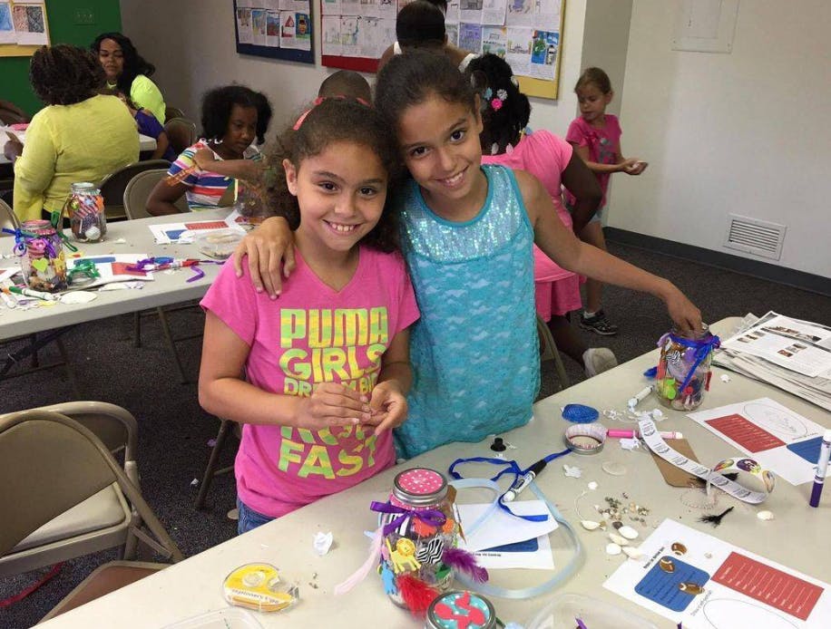 Two children standing at a table with craft supplies