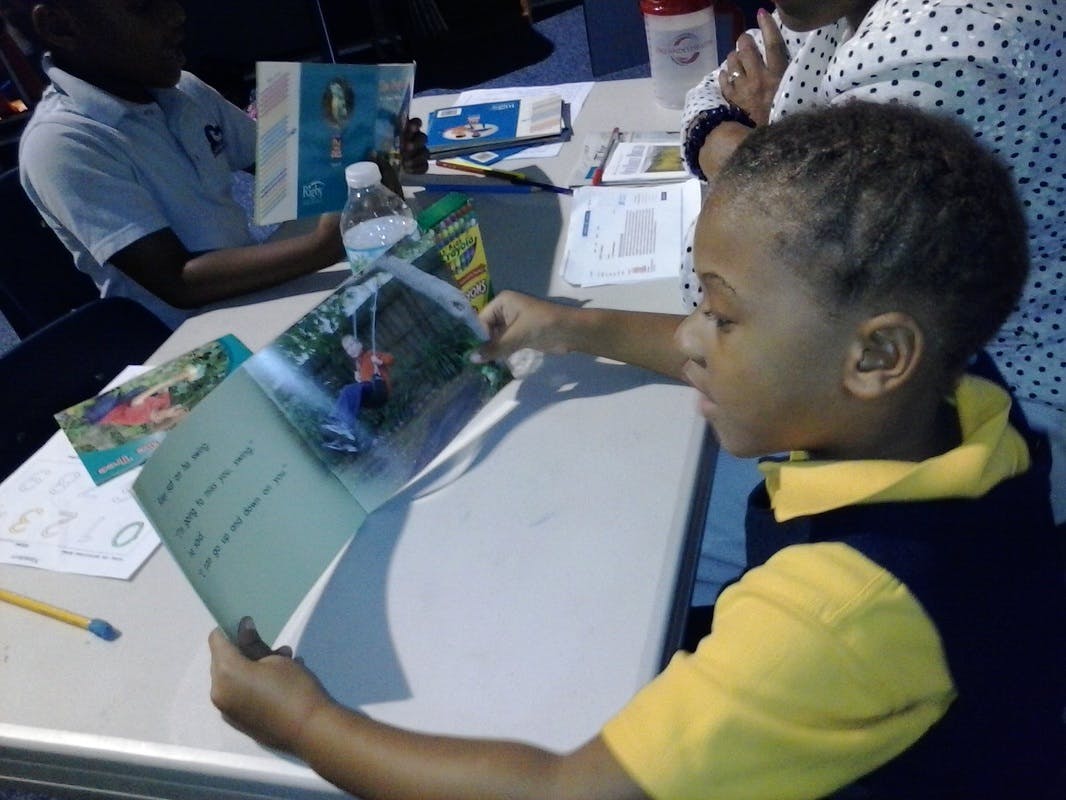 Child reading a book at a table