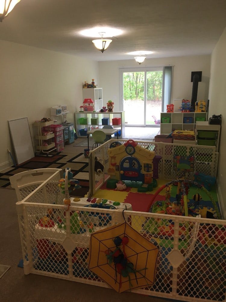 Playroom with a large playpen containing toys and a playmat
