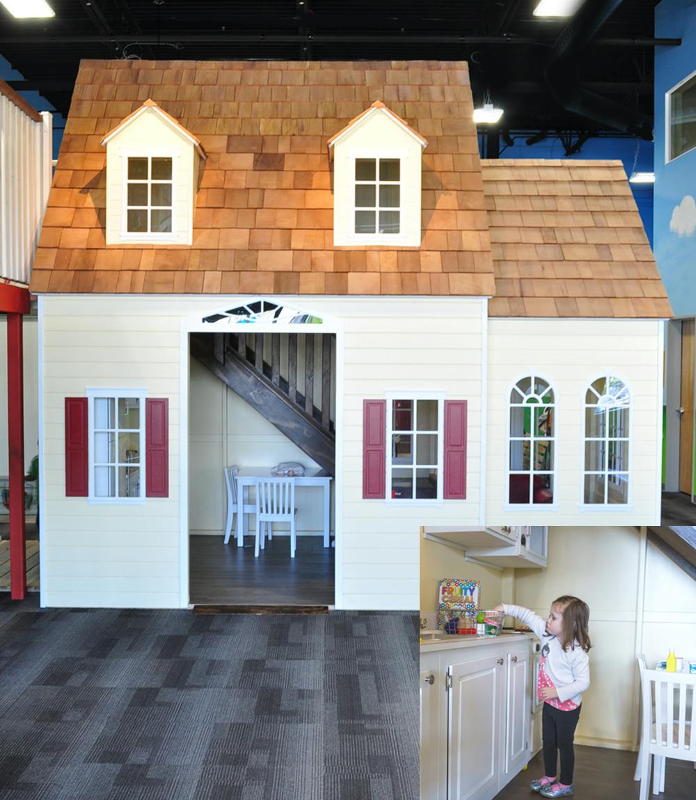 Child playing in a toy kitchen inside a playhouse