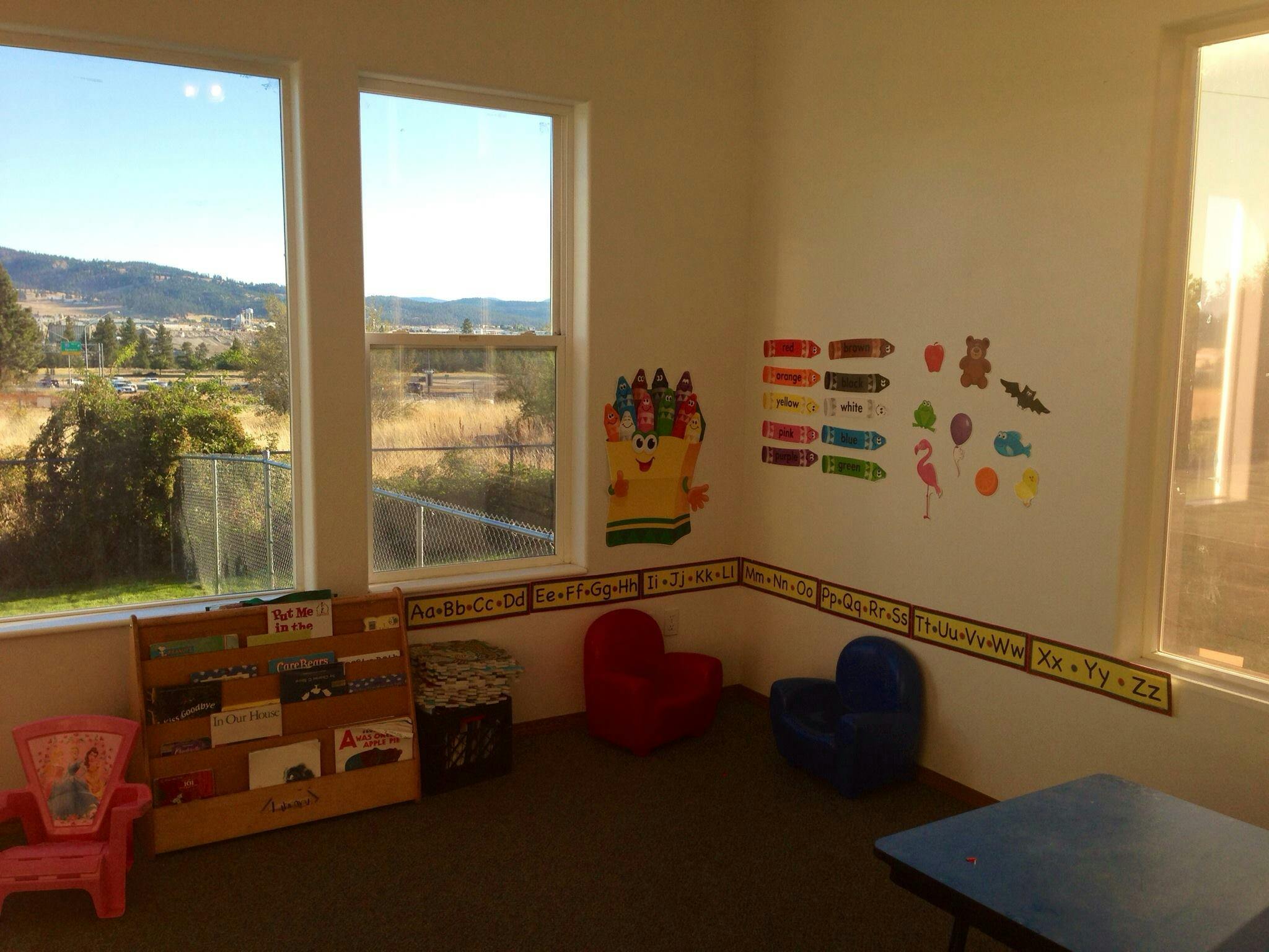Children's room with windows, small chairs, and wall decorations