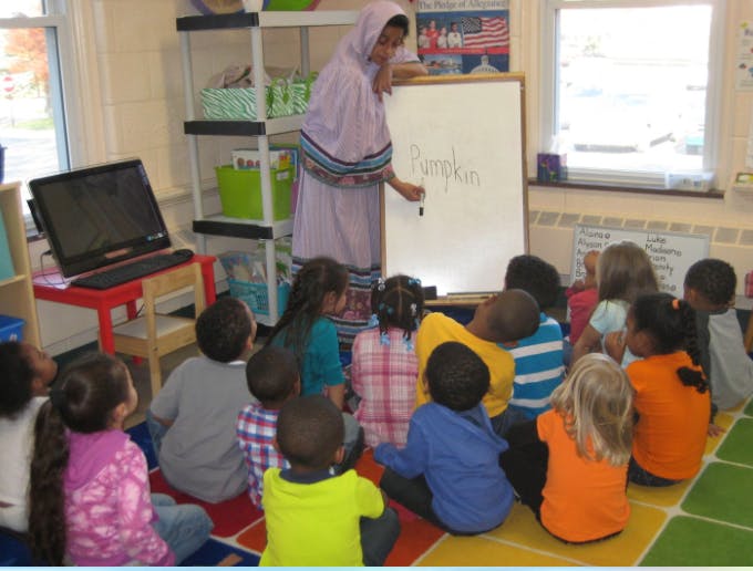 Person teaching children sitting on the floor in a classroom