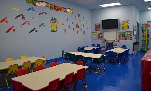 Classroom with small tables and chairs, decorated walls
