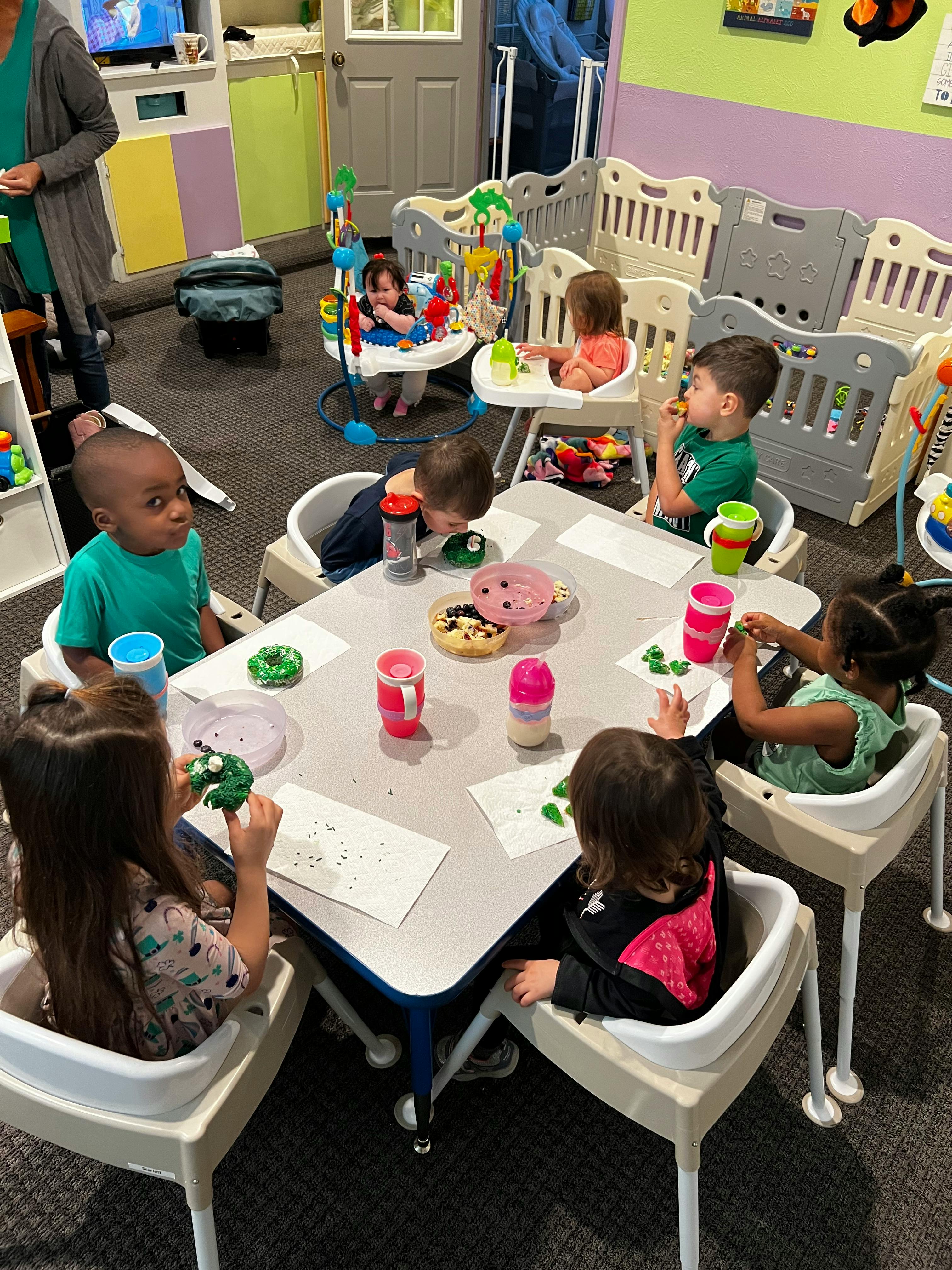 Children sitting at a table eating snacks in a classroom
