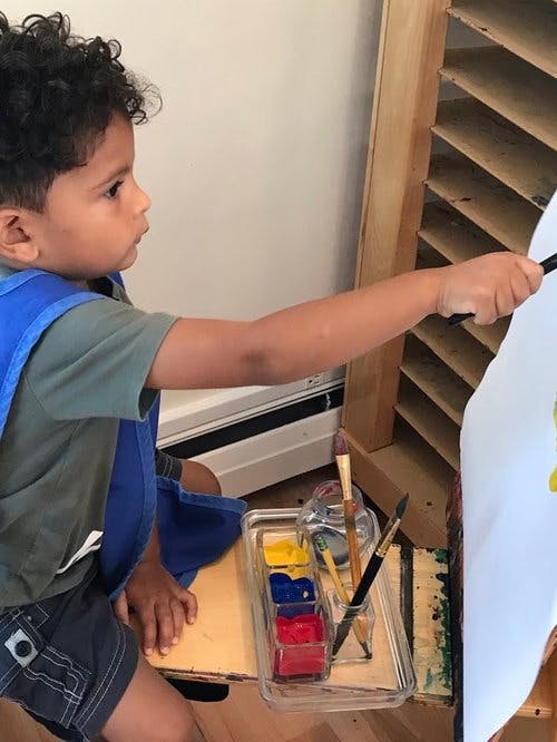 Child painting on an easel