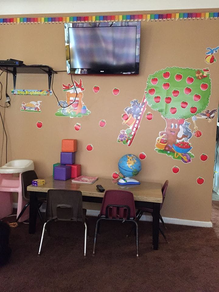 Children's play area with a table, chairs, blocks, and wall decorations