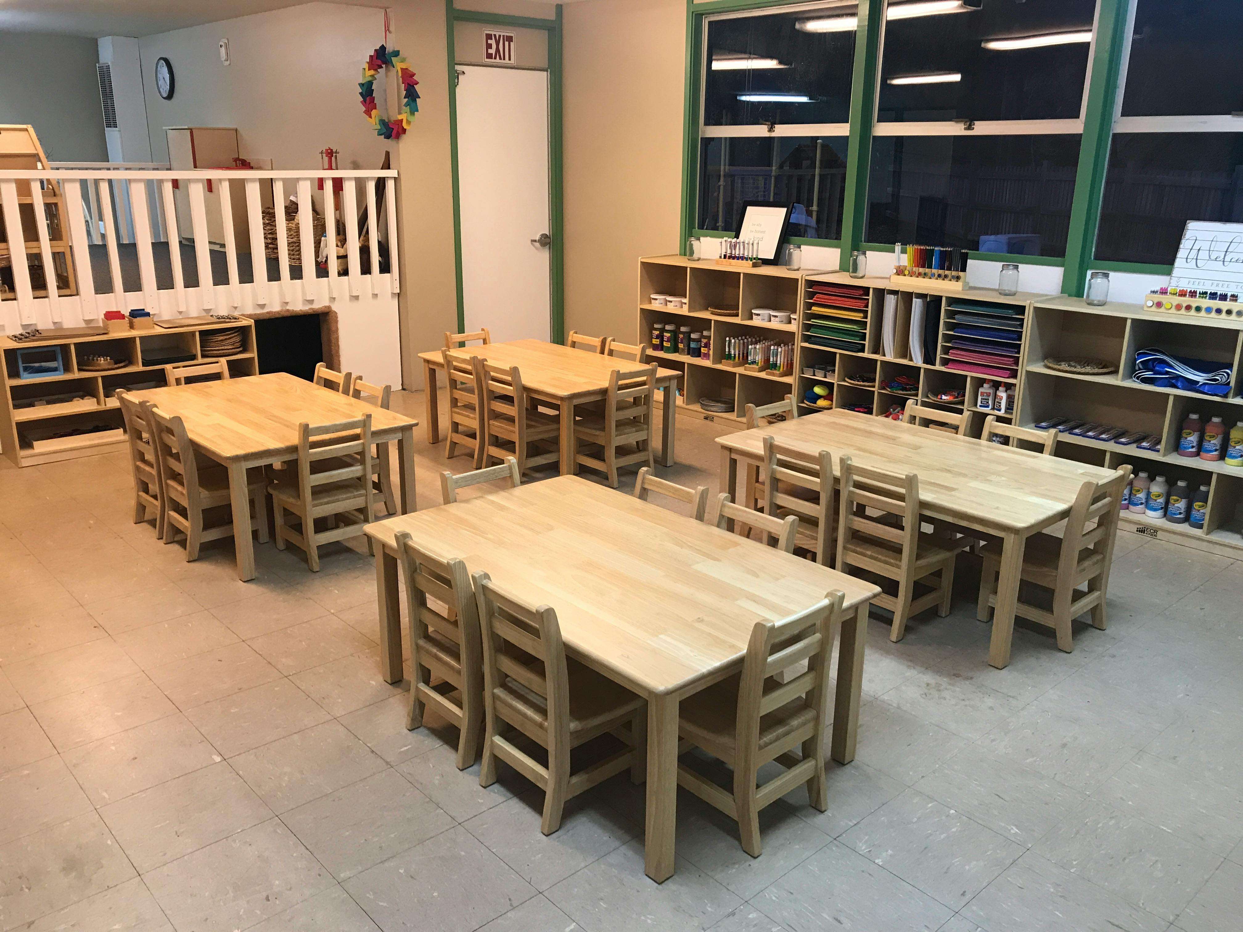Classroom with multiple wooden tables and chairs