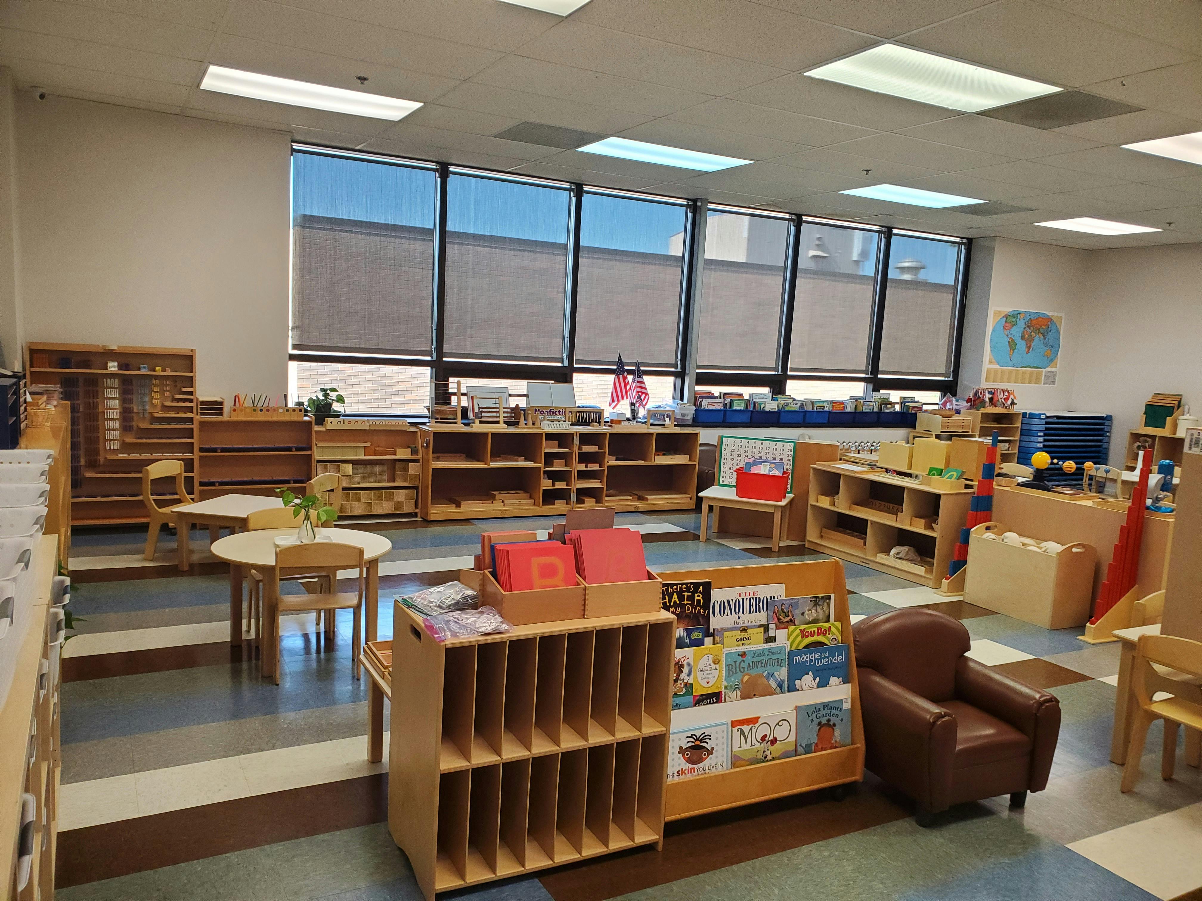 Classroom with wooden shelves, tables, and chairs