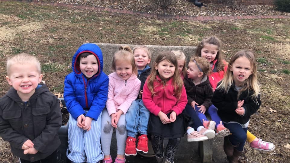 Group of children sitting on a bench outdoors