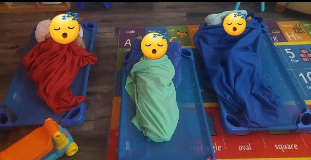 Three children sleeping on cots