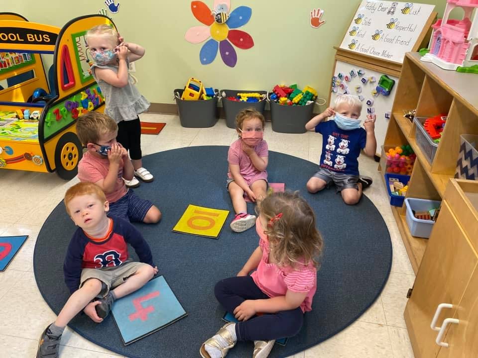 Children in a classroom sitting on a rug