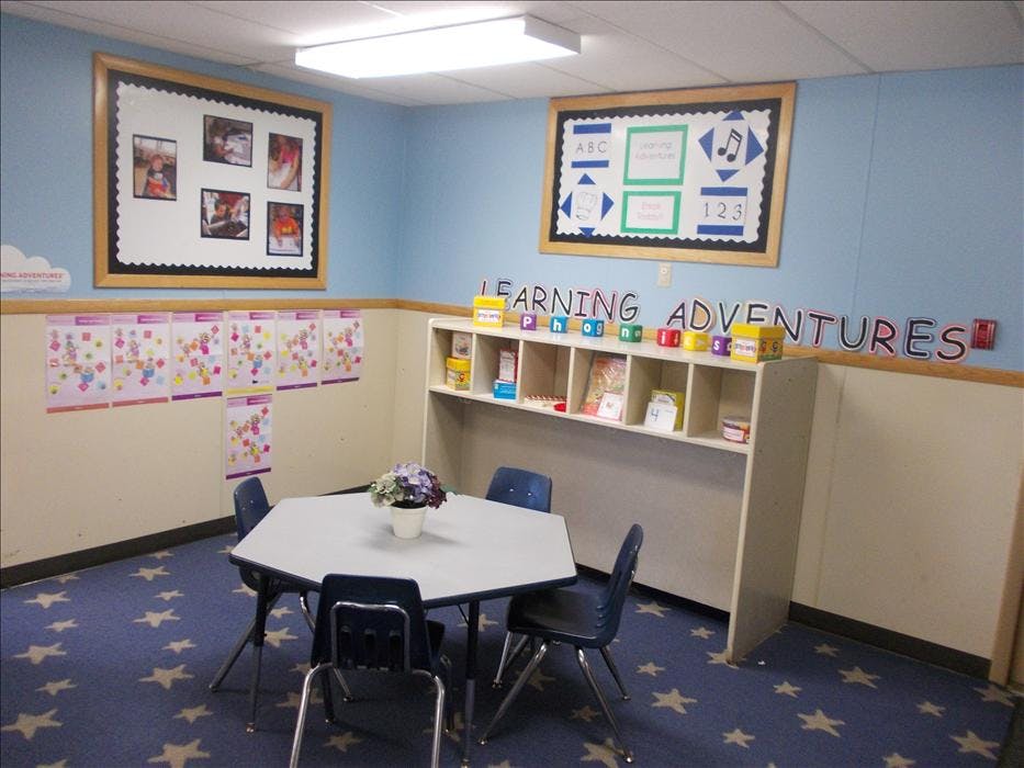 Learning Adventures classroom with a table, chairs, and colorful displays