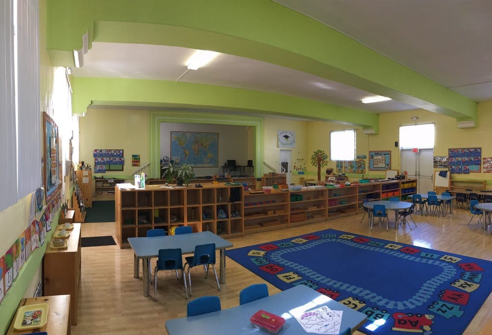 Classroom with small tables, chairs, and storage shelves