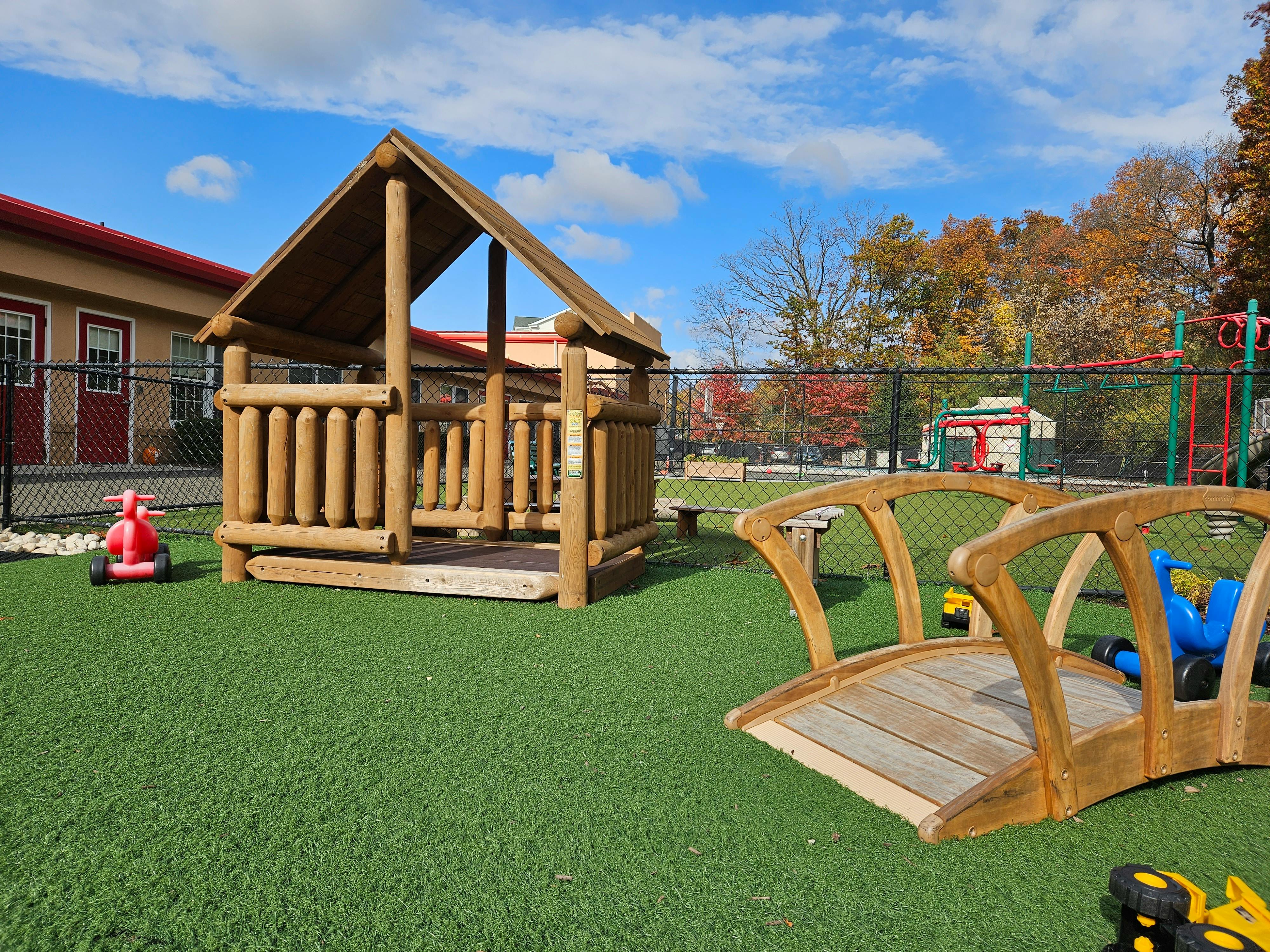 Wooden playhouse and bridge on artificial turf playground