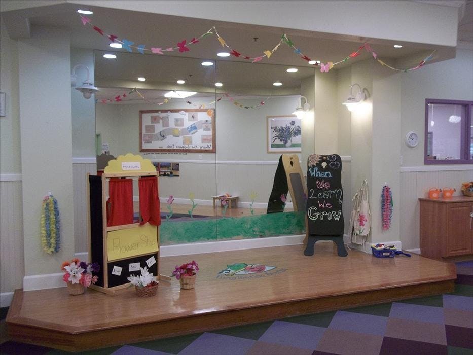 Flower Shop puppet stage with flowers on a wooden platform and patterned floor