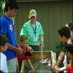 Adult and children gathered around a water table