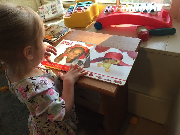 Child looking at an open book on a table