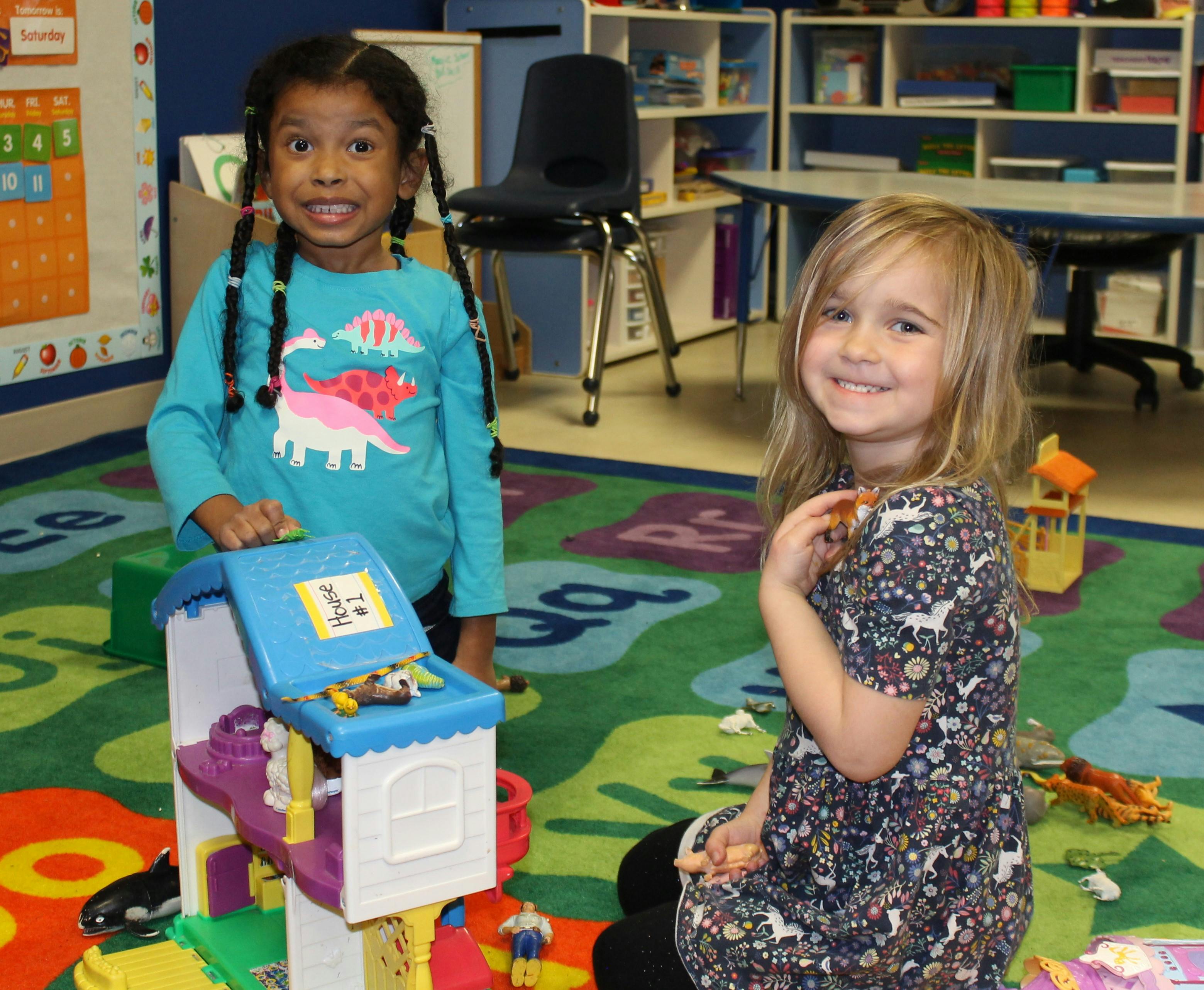 Two children playing with toys in a classroom
