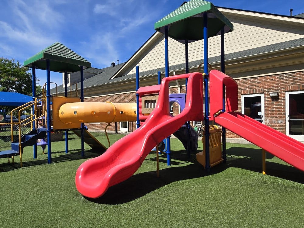 Colorful playground structure with slides and tunnels on artificial turf