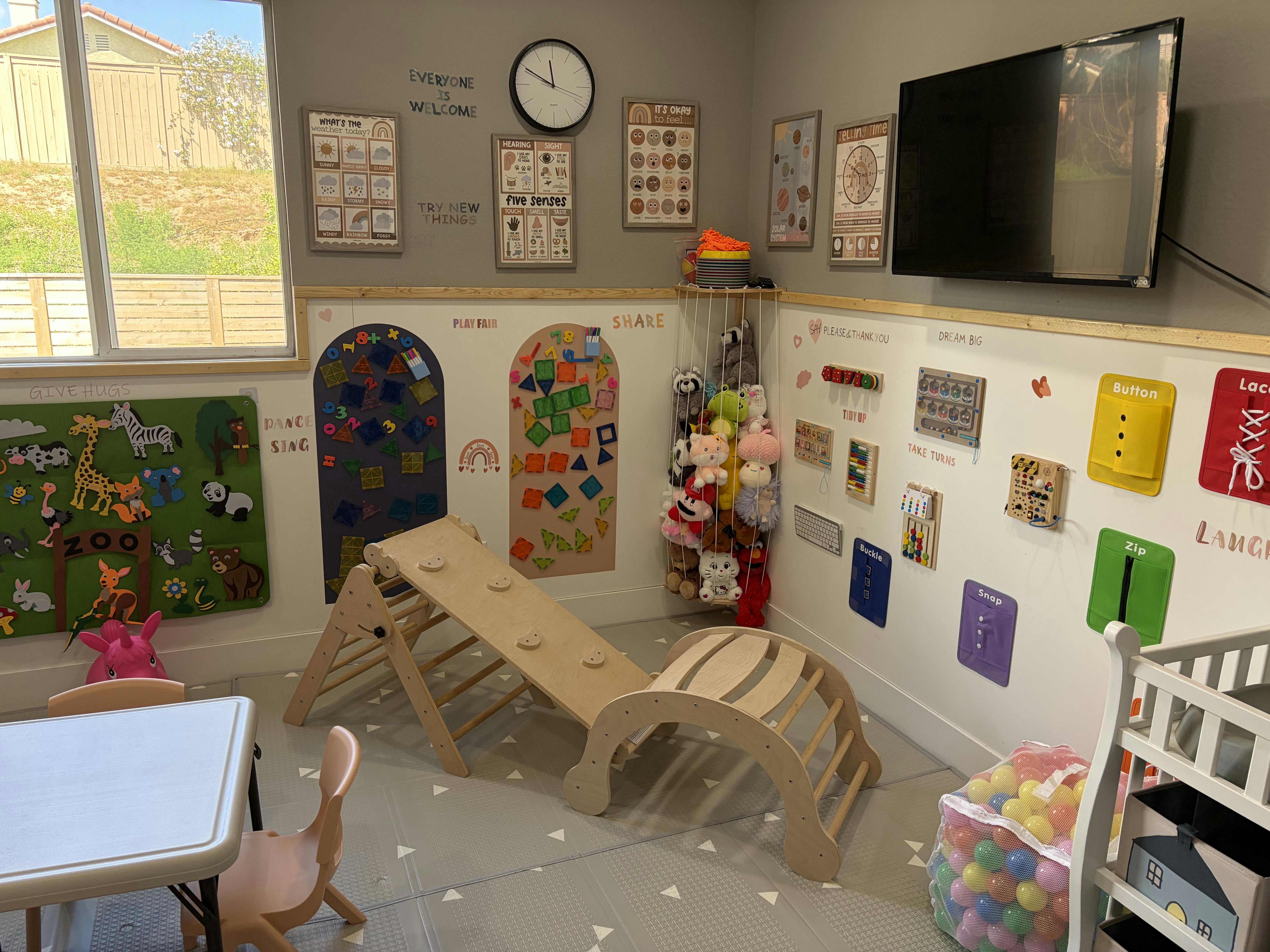 Children's playroom with various educational charts, climbing structures, and toys