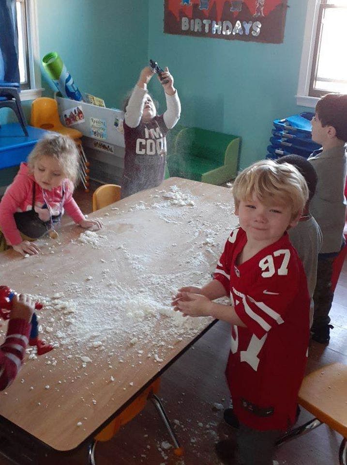 Children playing with flour on a table