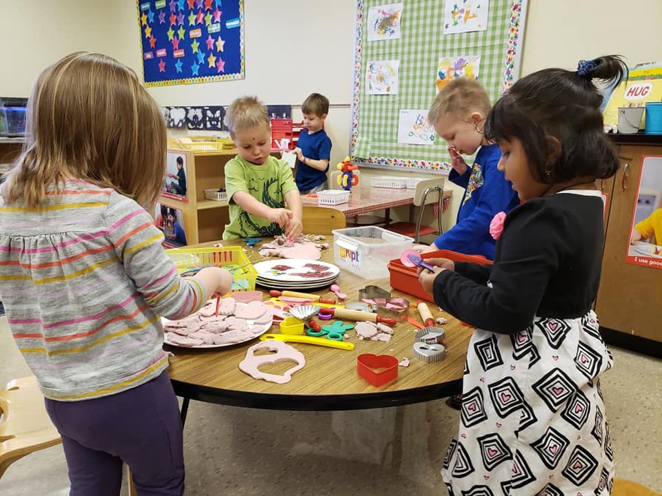 Children playing with modeling clay at a table