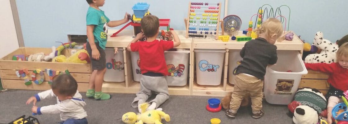 Multiple children playing with toys in a room