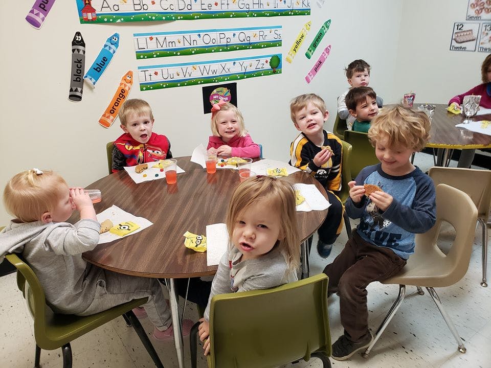 Children sitting at tables in a classroom