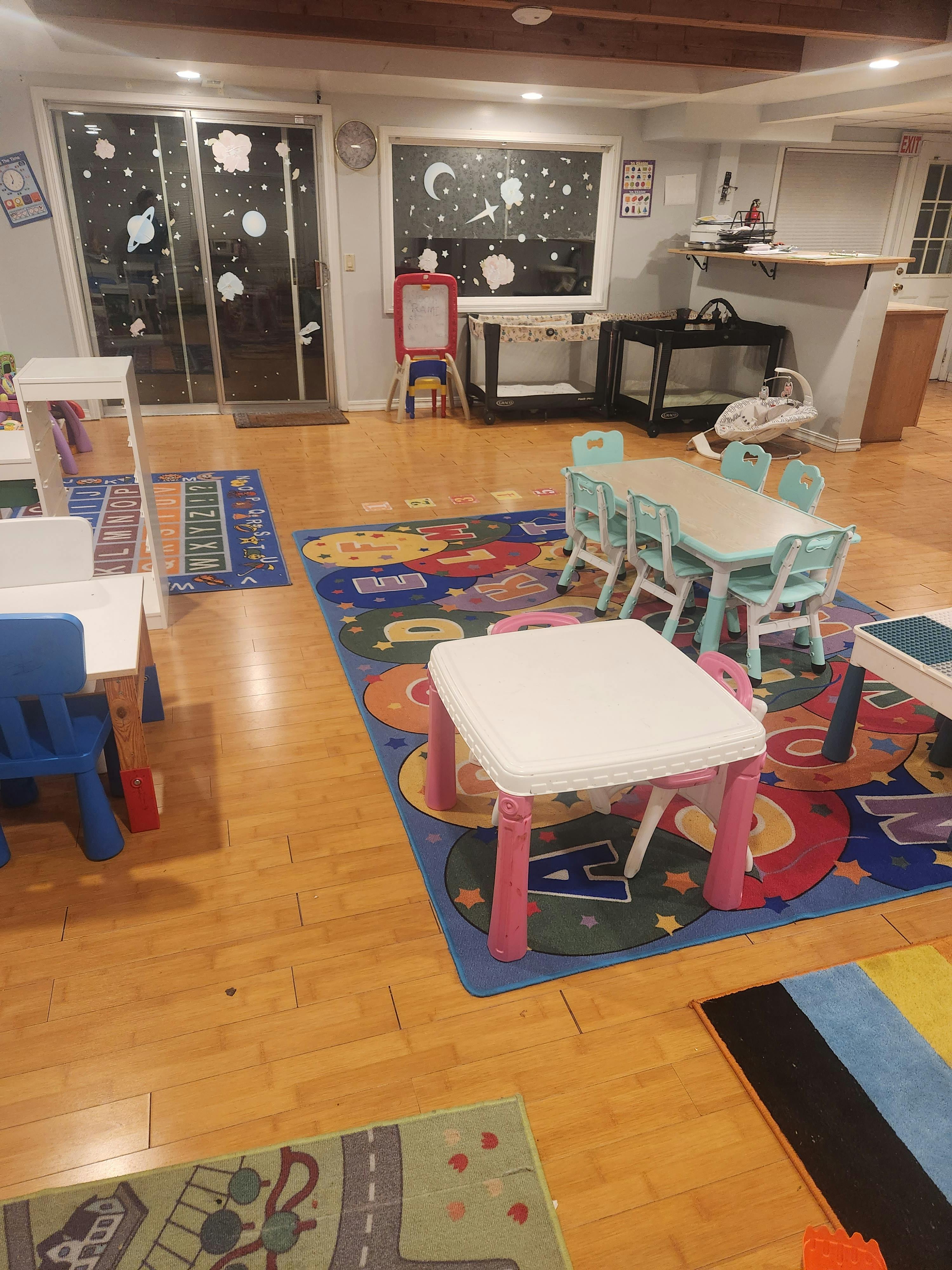 Playroom with small tables and chairs on colorful rugs