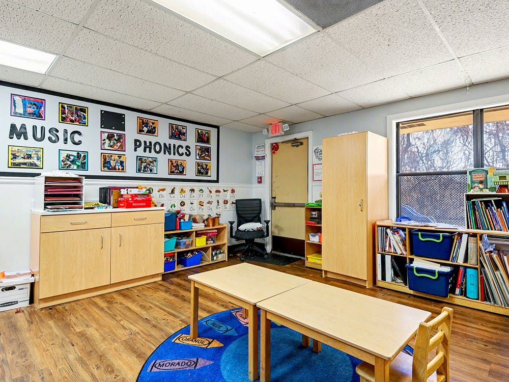 Classroom with music and phonics displays, small tables, and bookshelves