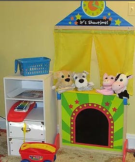Puppet theater with stuffed animal puppets and a storage shelf