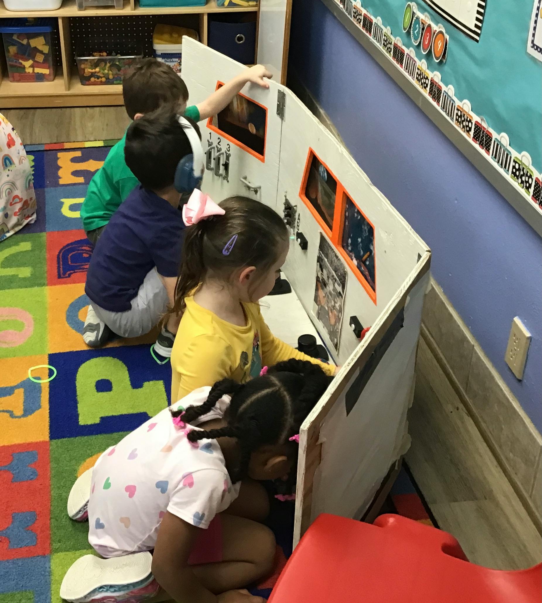 Children playing with a display board in a classroom