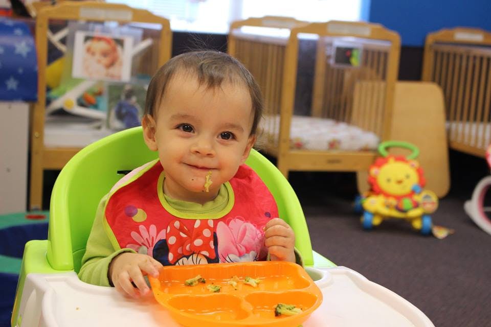 Child in a high chair with food on a tray