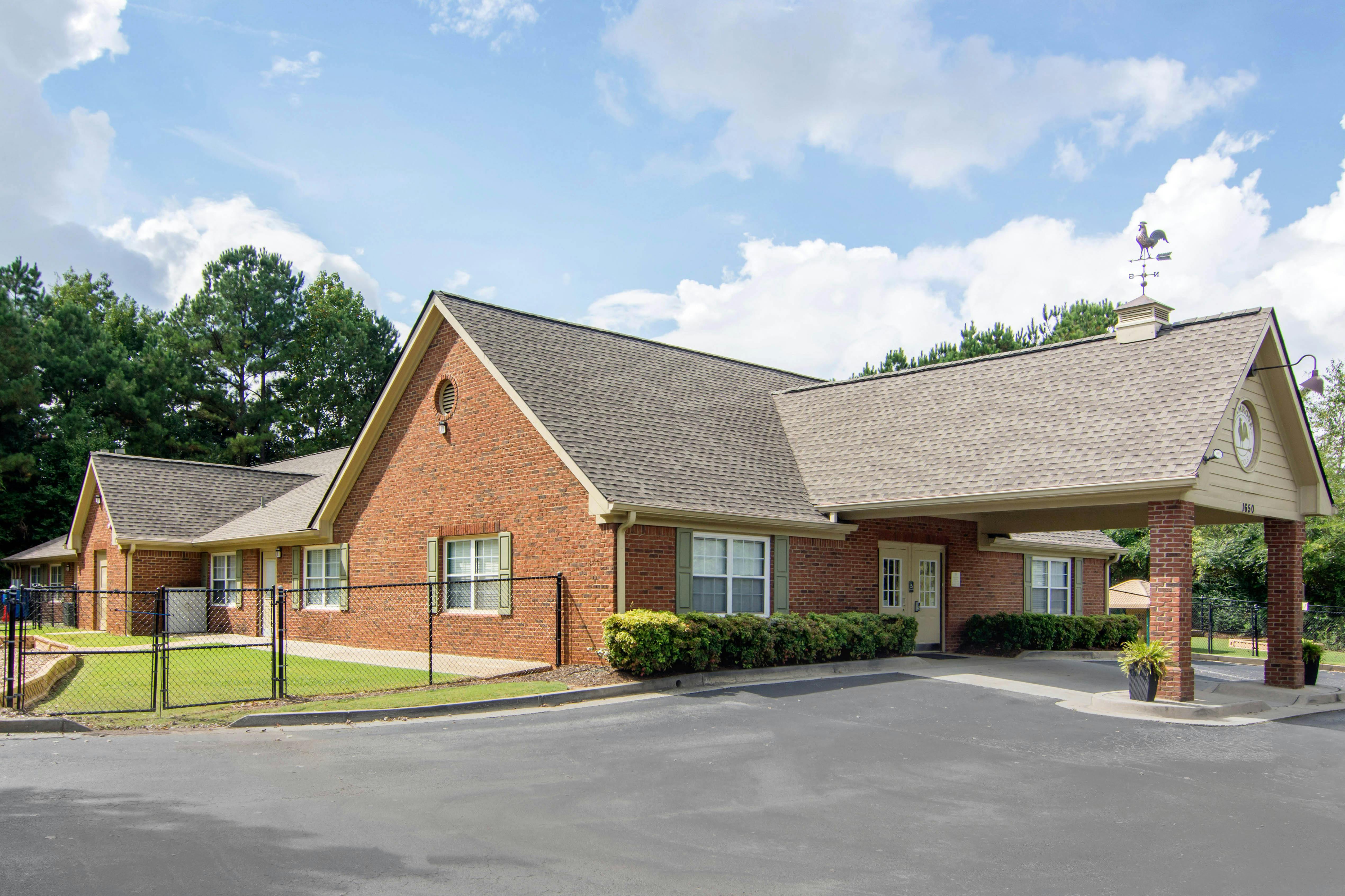Brick building with a covered entrance and a weather vane on the roof