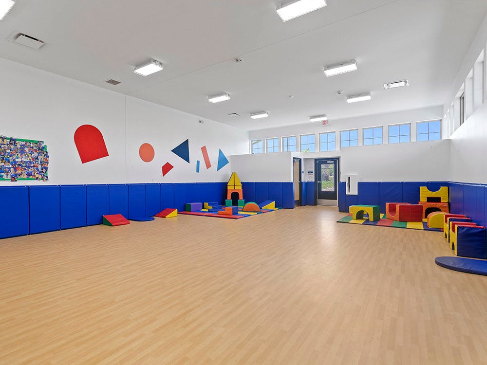 Playroom with soft play equipment on light wood flooring