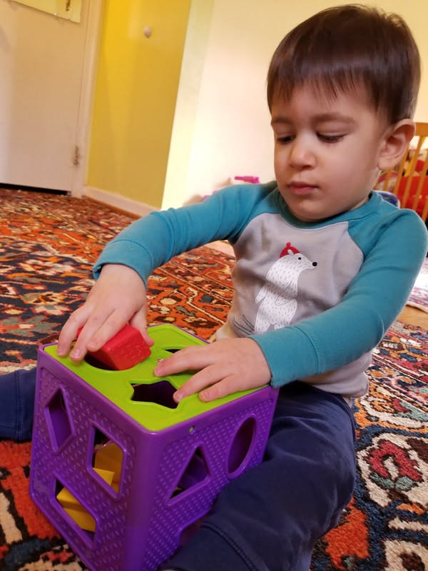 Child playing with a shape sorter toy