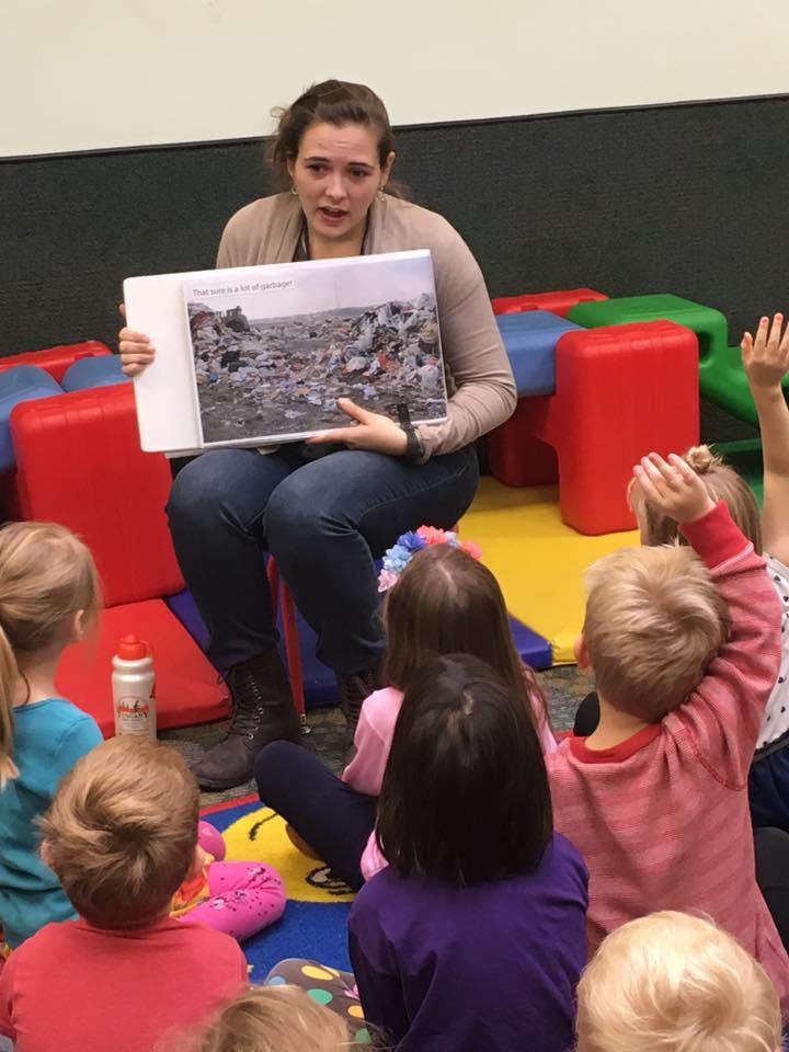 Person showing children a picture of a landfill