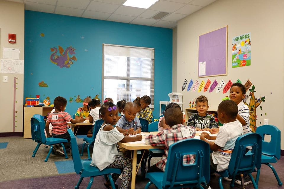 Children sitting at tables in a classroom