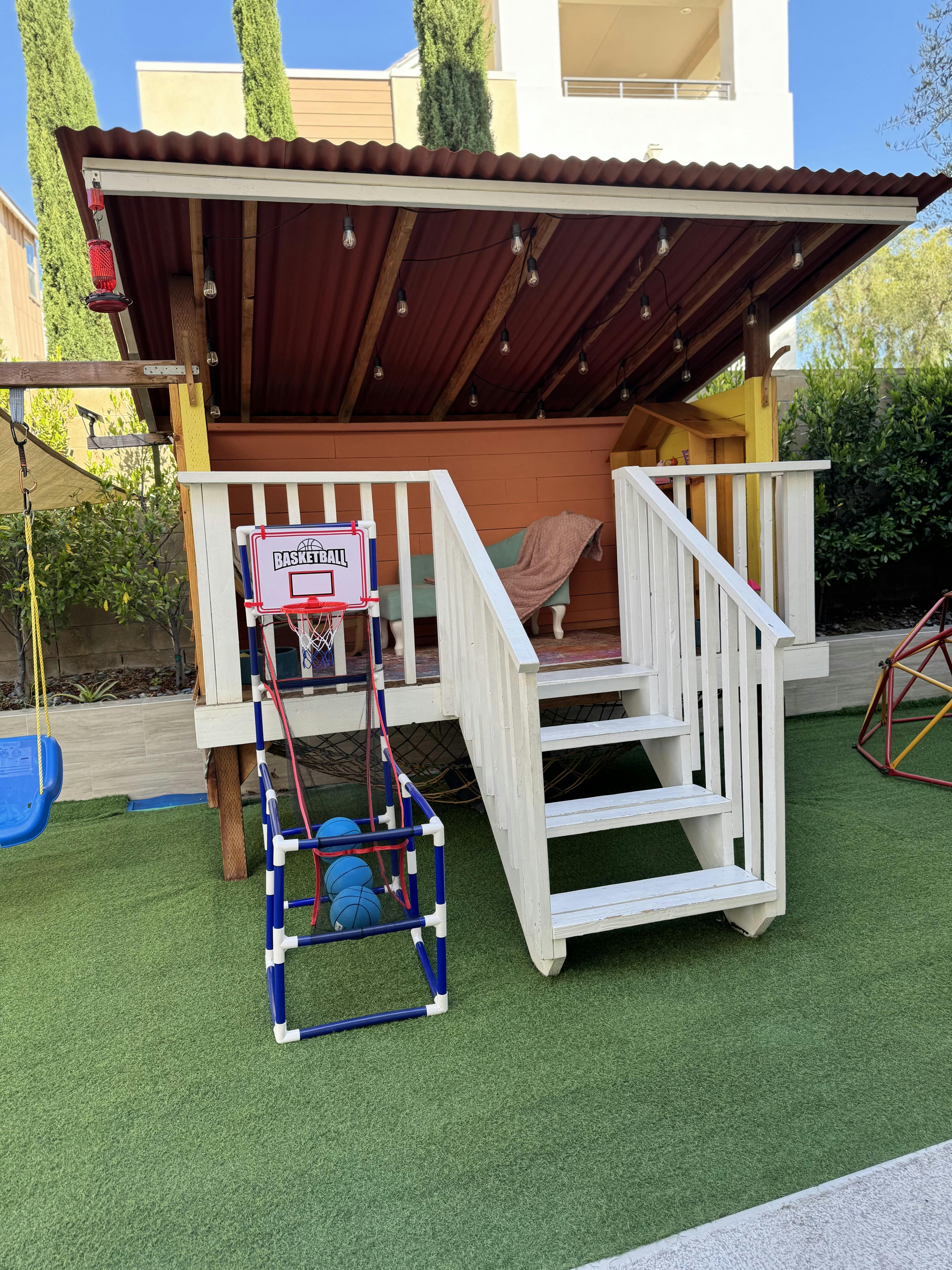 Playhouse with a front porch, stairs, and a basketball arcade game