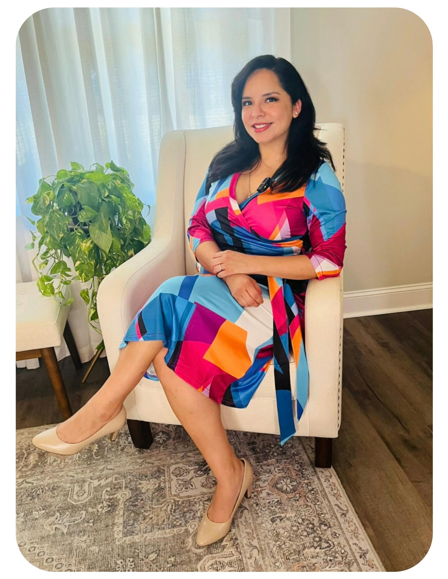 Person in a colorful patterned dress sitting in an armchair