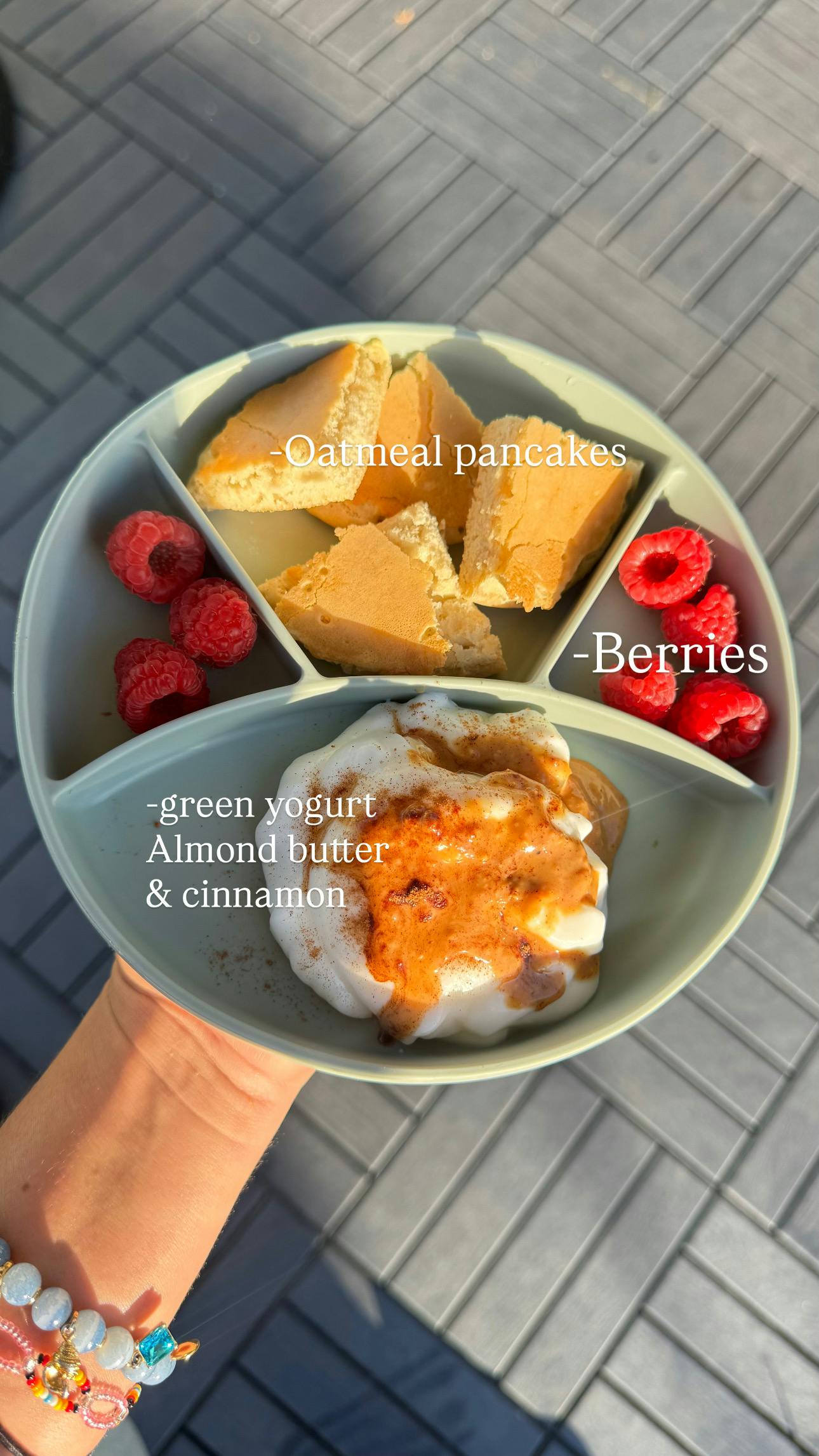 Sectioned plate with oatmeal pancakes, berries, and yogurt with almond butter