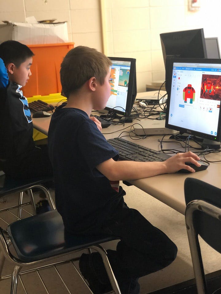 Child using a computer mouse in a classroom