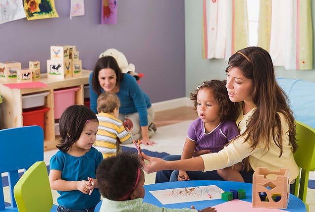 Adults and children interacting in a classroom