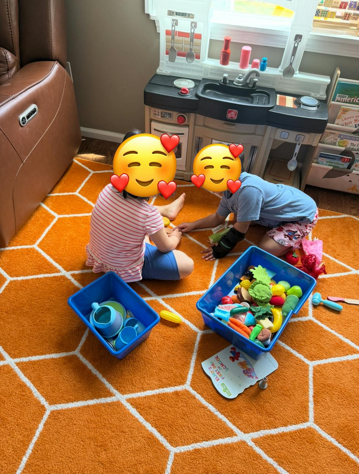 Two children playing with toy food and kitchen set