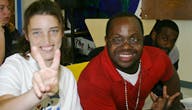 Person making a peace sign next to another person
